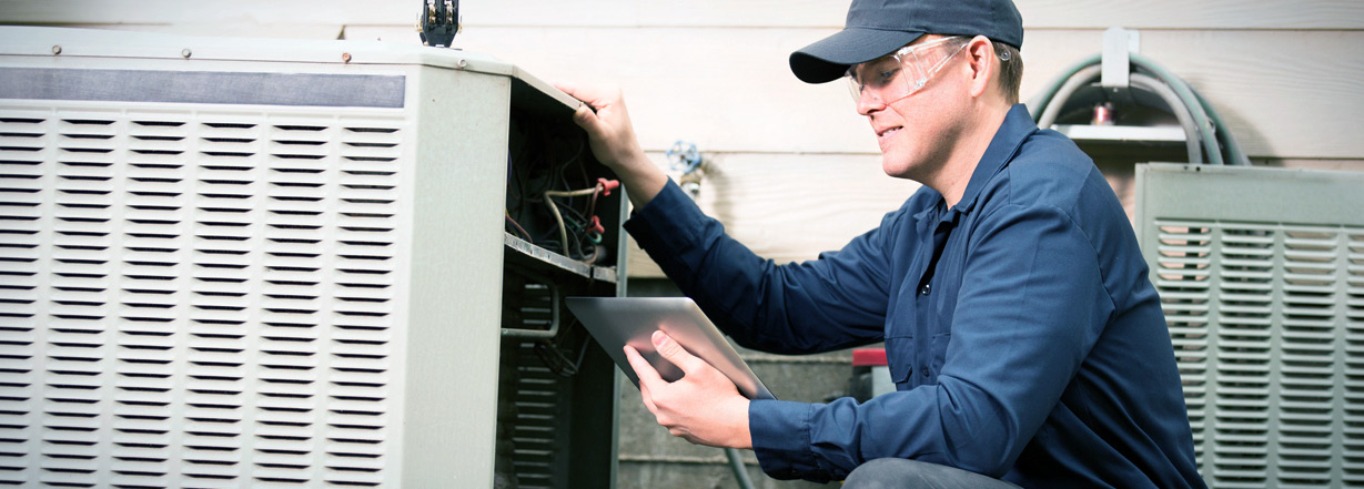  Image of technician working on industrial air conditioner outdoor unit.